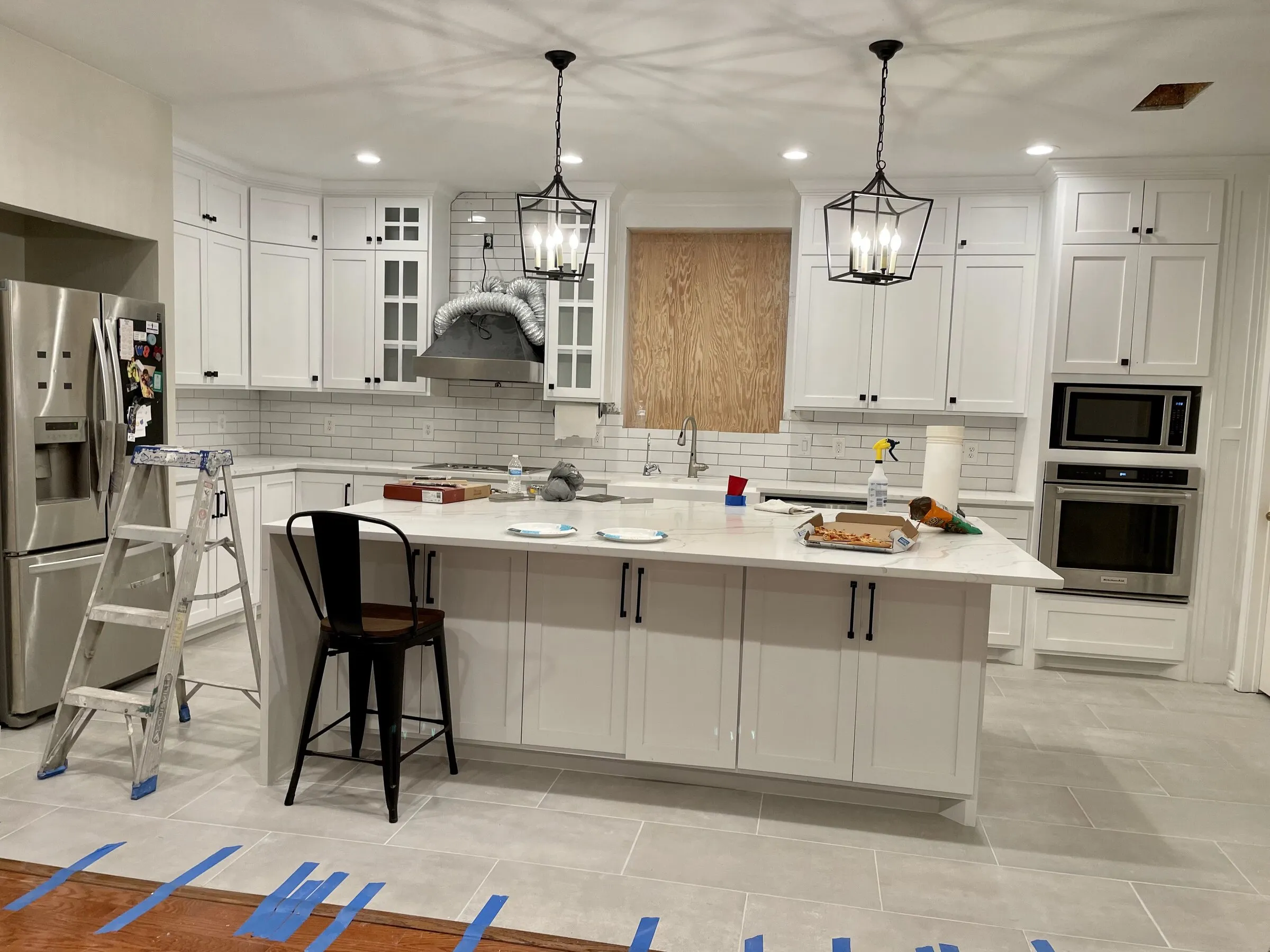 Kitchen with custom range hood and built-in microwave by IonBuilds