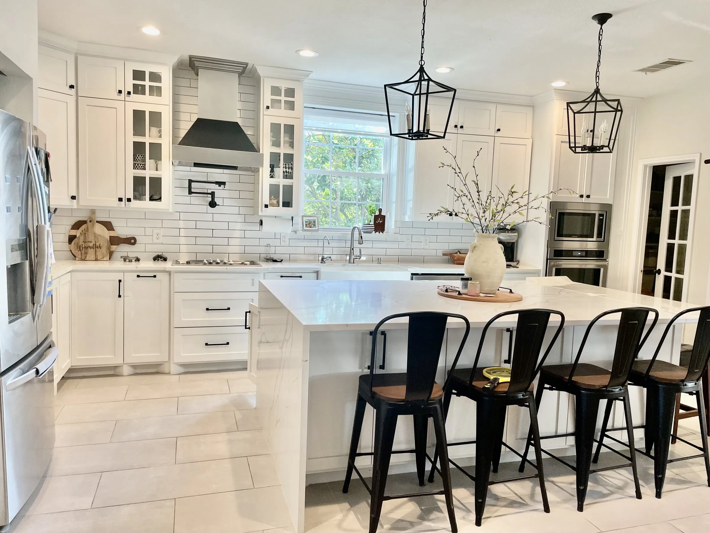 White kitchen overview with island seating by IonBuilds